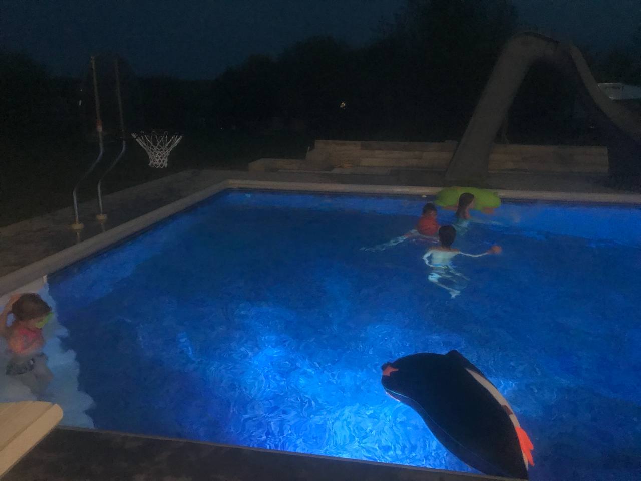 Pool at night with kids swimming